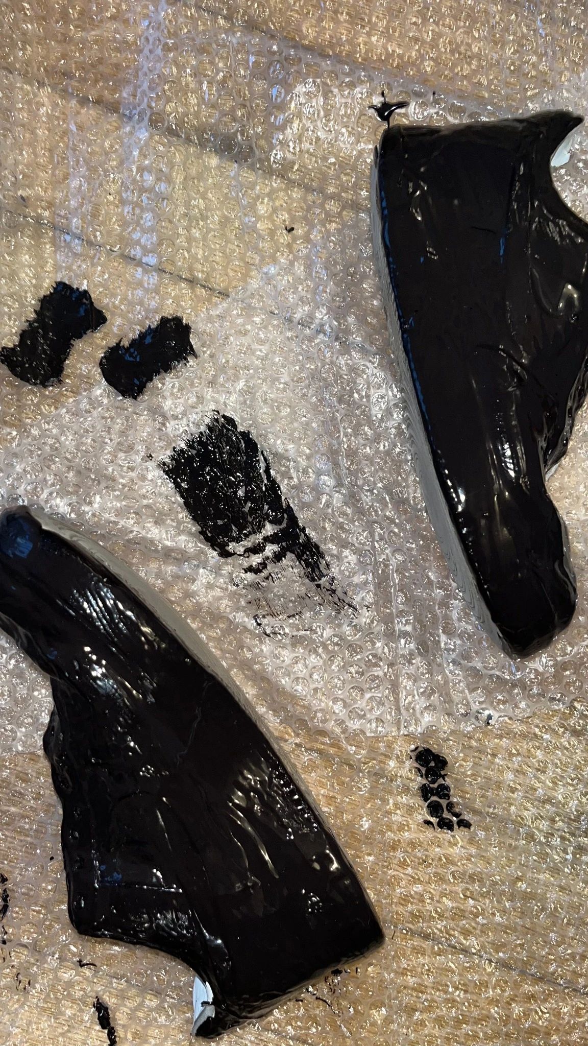 Scarpe nere — Applicazione di gomma liquida e successiva verniciatura.